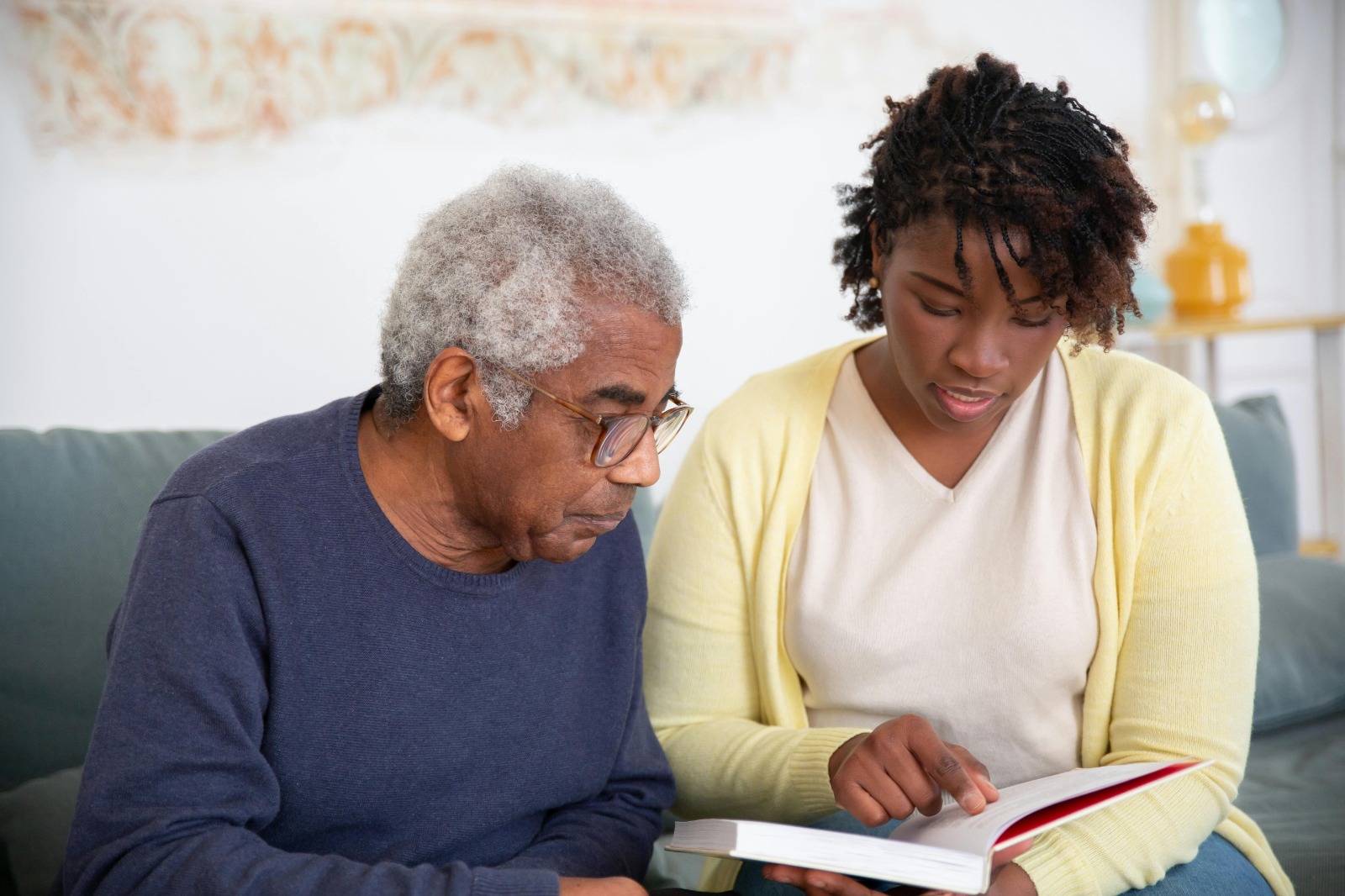 A OpenArms HCS caregiver wearing gloves cleans a dining table with care, emphasizing thoroughness and attention to maintaining a clean, comfortable home.